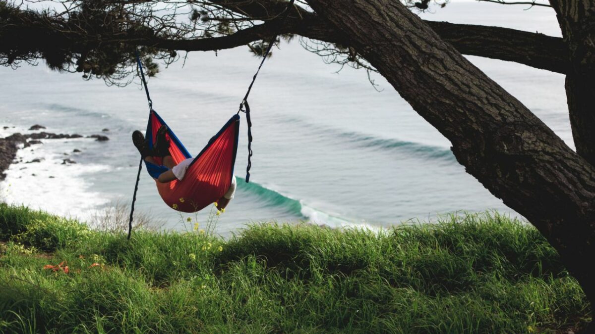 A camper in a hammock gazes out towards the ocean in Big Sur