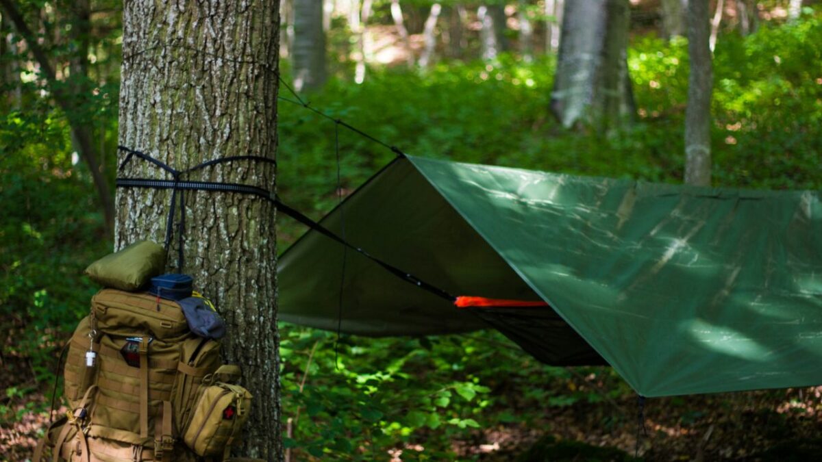 A hammock and a backpack in the woods